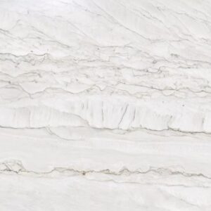 Close-up of a white marble surface with grayish veins running horizontally across it. The texture shows a mix of smooth and rough areas, highlighting the natural patterns typical of marble stone.