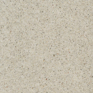 A close-up of a light beige terrazzo surface with small, scattered fragments of stone in various colors including gray, brown, and off-white, creating a speckled pattern.