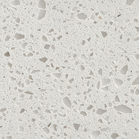 Close-up of a light grey terrazzo surface featuring dispersed, irregularly shaped fragments in varying shades of grey and white, creating a speckled and textured appearance.