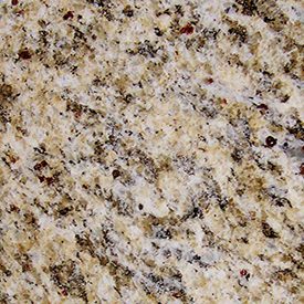 Close-up of a granite surface showing a mix of beige, white, black, and brown speckles. The texture is rough, with natural variations in color and pattern.