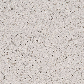 Close-up of a light gray, speckled terrazzo surface with small black, white, and brown stone fragments scattered throughout. The texture appears smooth and polished.