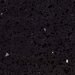 Close-up of a black granite countertop with a polished surface featuring small reflective specks and a few scattered pieces of light-colored stone. The texture is slightly uneven, providing a visually dynamic pattern.