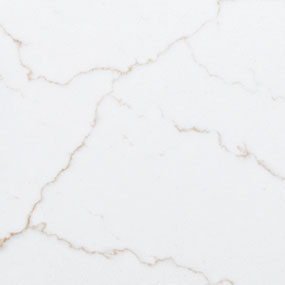 A close-up of white marble surface featuring subtle, light brown veins that create a natural and elegant pattern across the stone.